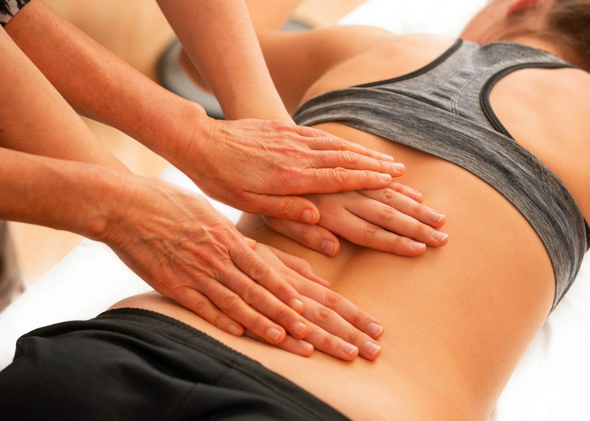 Physiotherapeutische Behandlung des Rückens mit beiden Händen
